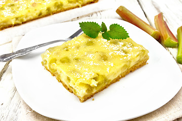 Image showing Kukhen with rhubarb and pudding in plate on wooden board