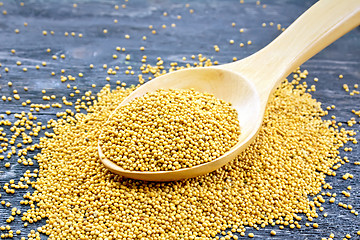 Image showing Mustard seeds in wooden spoon on board