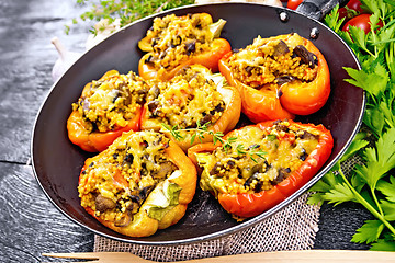 Image showing Pepper stuffed with mushrooms and couscous in pan on board