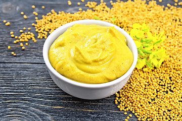 Image showing Sauce mustard in bowl with flower on board