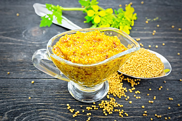 Image showing Sauce mustard Dijon in sauceboat with flower on wooden board