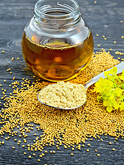 Image showing Mustard powder in spoon with oil and flower on board