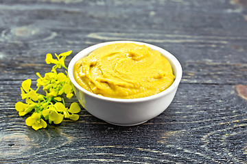 Image showing Sauce mustard in bowl with flower on dark board