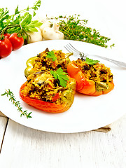 Image showing Pepper stuffed with mushrooms and couscous in white plate on boa