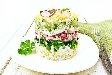 Image showing Salad layered with radish and cucumber in plate on board