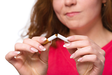 Image showing Young woman is breaking a cigarette