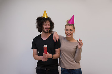 Image showing couple in party hats blowing in whistle