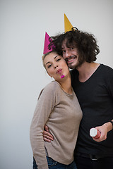 Image showing couple in party hats blowing in whistle