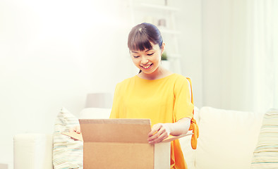 Image showing happy asian young woman with parcel box at home