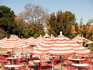 Image showing Umbrellas over empty tables and chairs outdoor cafe