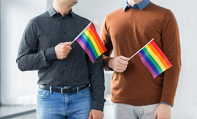 Image showing close up of happy male couple with gay pride flags