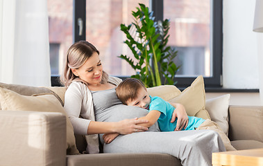 Image showing happy pregnant mother and son hugging at home