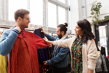 Image showing friends choosing clothes at vintage clothing store