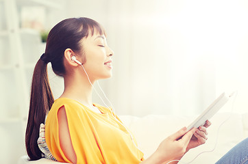 Image showing happy asian woman with tablet pc and earphones