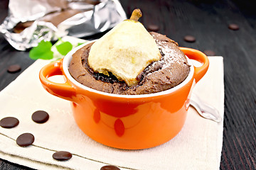 Image showing Cake chocolate with pear in red bowl on towel