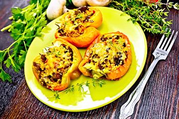 Image showing Pepper stuffed with mushrooms and couscous in green plate on boa