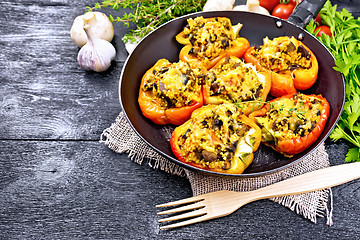 Image showing Pepper stuffed with mushrooms and couscous in old pan on board