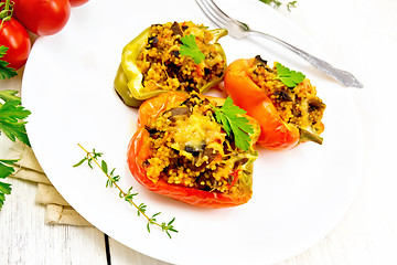 Image showing Pepper stuffed with mushrooms and couscous in plate on board