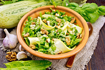 Image showing Salad with squash and sorrel in clay plate on board