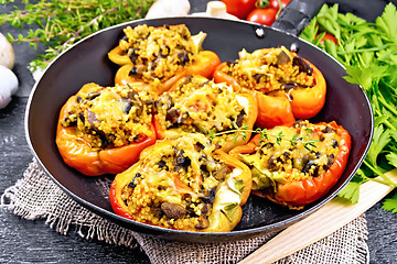 Image showing Pepper stuffed with mushrooms and couscous in pan on black board