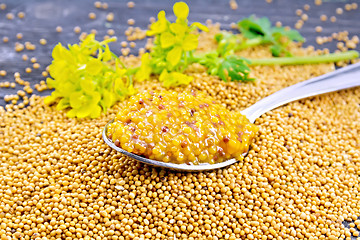 Image showing Sauce mustard Dijon in spoon with flower on wooden board