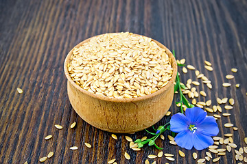 Image showing Flaxen white seed in bowl with blue flower on board