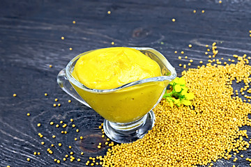 Image showing Sauce mustard in sauceboat with flower on wooden board