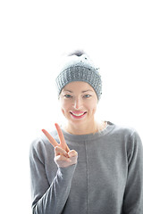 Image showing Close up portrait of cheerful caucasian woman, gesturing peace sign and smiles