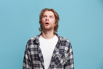 Image showing The young attractive man looking suprised isolated on blue