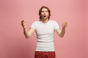 Image showing The young attractive man looking suprised isolated on blue