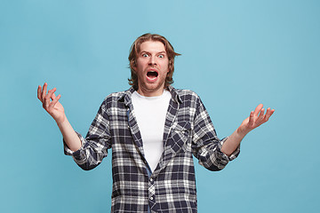 Image showing The young attractive man looking suprised isolated on blue