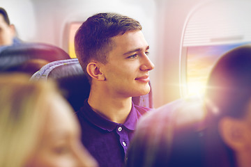 Image showing happy young man travelling by plane