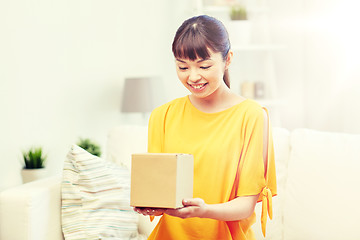 Image showing happy asian young woman with parcel box at home