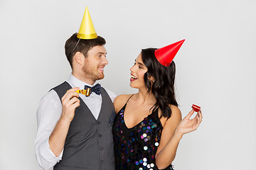 Image showing happy couple with party blowers having fun