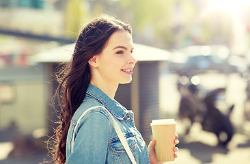 Image showing happy young woman drinking coffee on city street