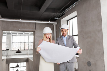 Image showing architects with blueprint and helmets at office