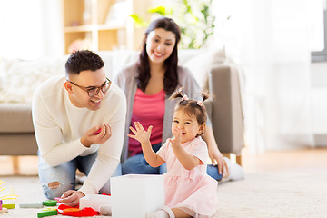 Image showing baby girl with birthday gift and parents at home 