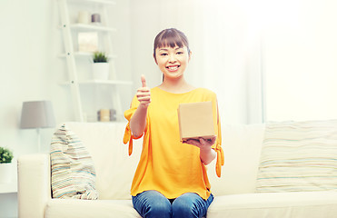 Image showing happy asian young woman with parcel box at home