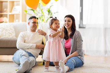 Image showing happy baby girl and parents at home birthday party