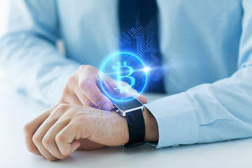 Image showing close up of hands with bitcoin on smart watch