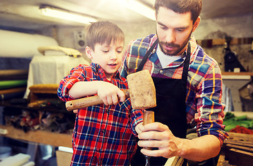 Image showing father and son with chisel working at workshop