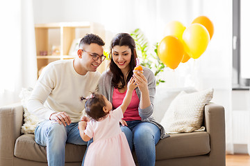 Image showing baby girl with parents at home birthday party