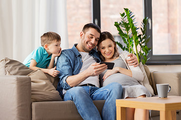 Image showing happy family with smartphone at home