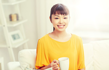 Image showing happy asian woman drinking from tea cup