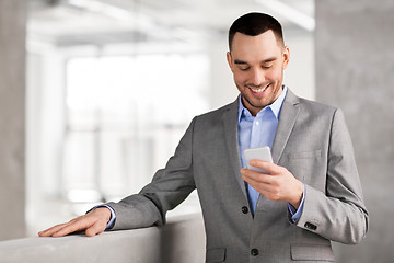 Image showing smiling businessman with smarphone at office