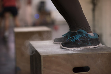 Image showing black woman is performing box jumps at gym