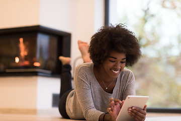 Image showing black women using tablet computer on the floor