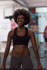 Image showing black woman lifting empty bar