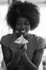 Image showing woman with afro hairstyle eating tasty pizza slice