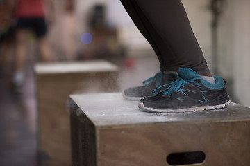 Image showing black woman is performing box jumps at gym